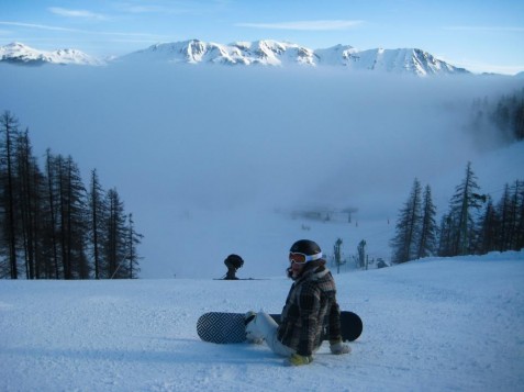 Snowboarder sat above the clouds